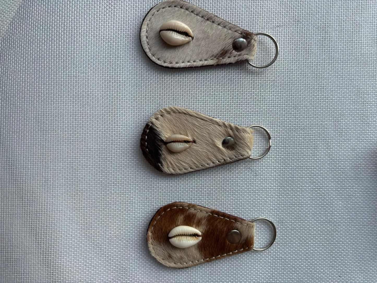 Carved Keychain — dark brown fur leather with cowrie shell close up