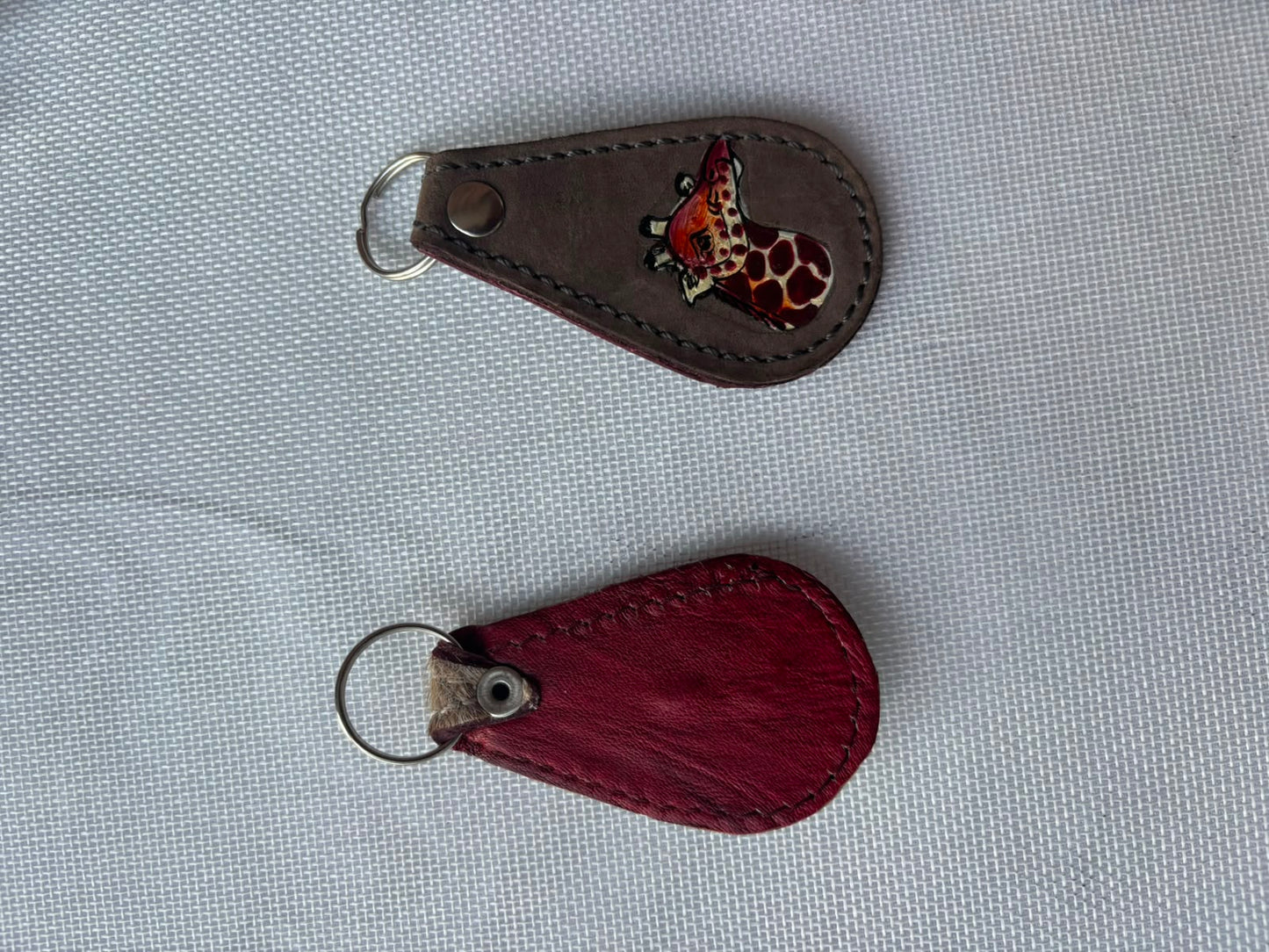 Buffalo Soldier Keychain — dark leather with giraffe emblem and plain red