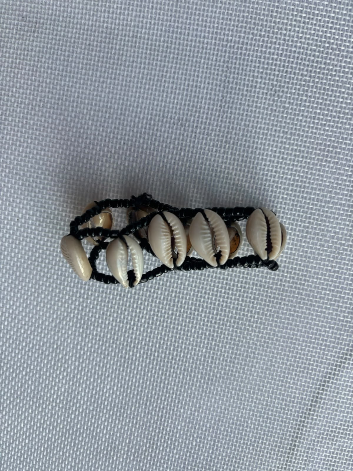 Cowrie shell bracelet on black woven cord