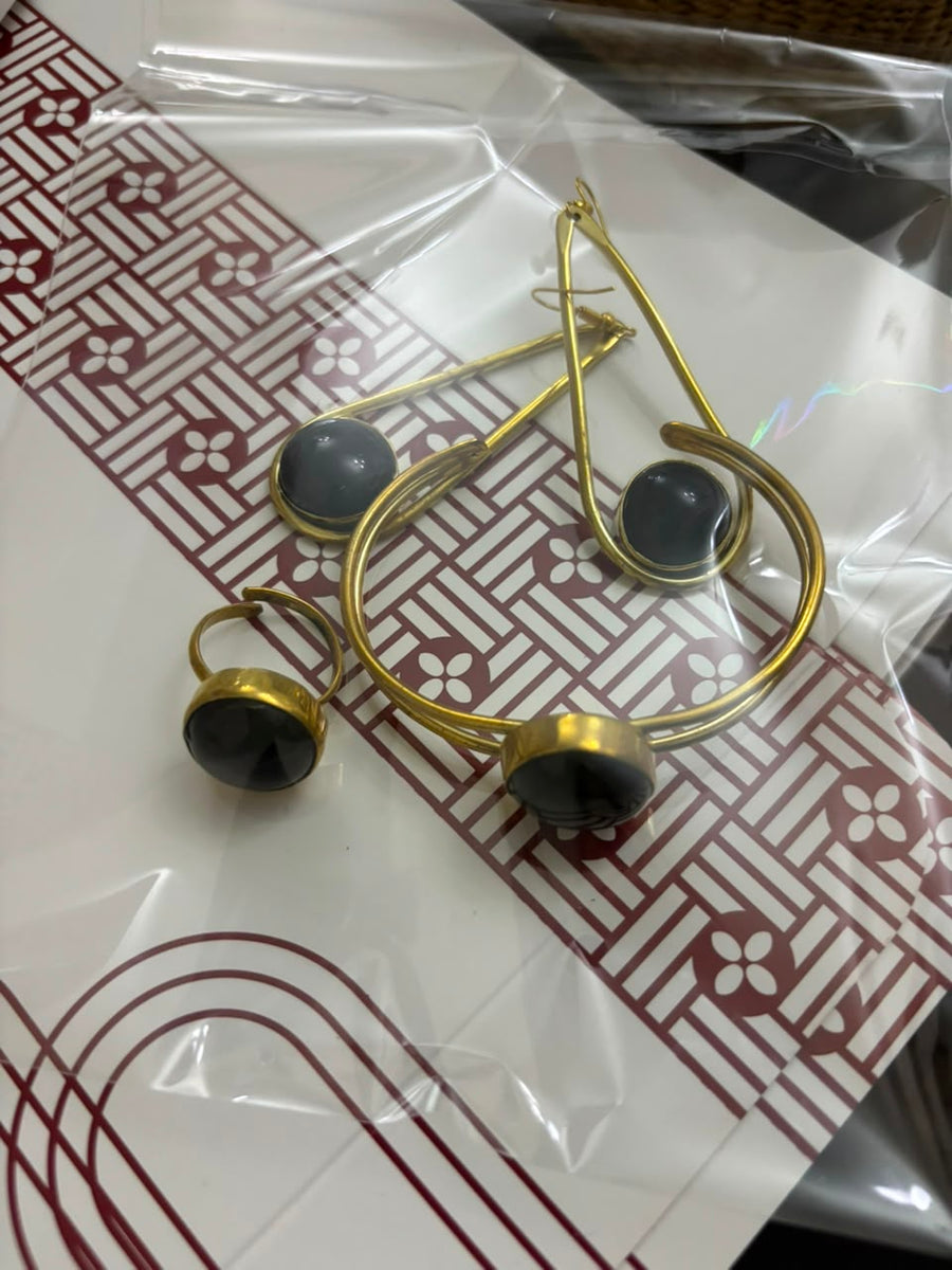 Gold-tone teardrop hoop earrings and ring with dark stone on SAHARA patterned paper