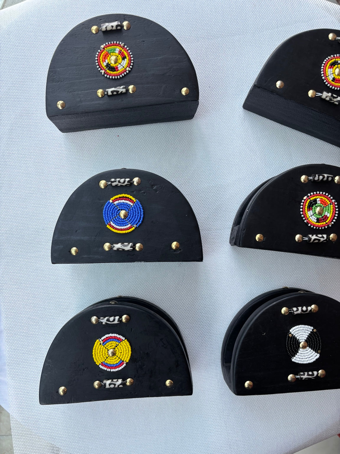 Black wooden napkin holders with colorful beadwork