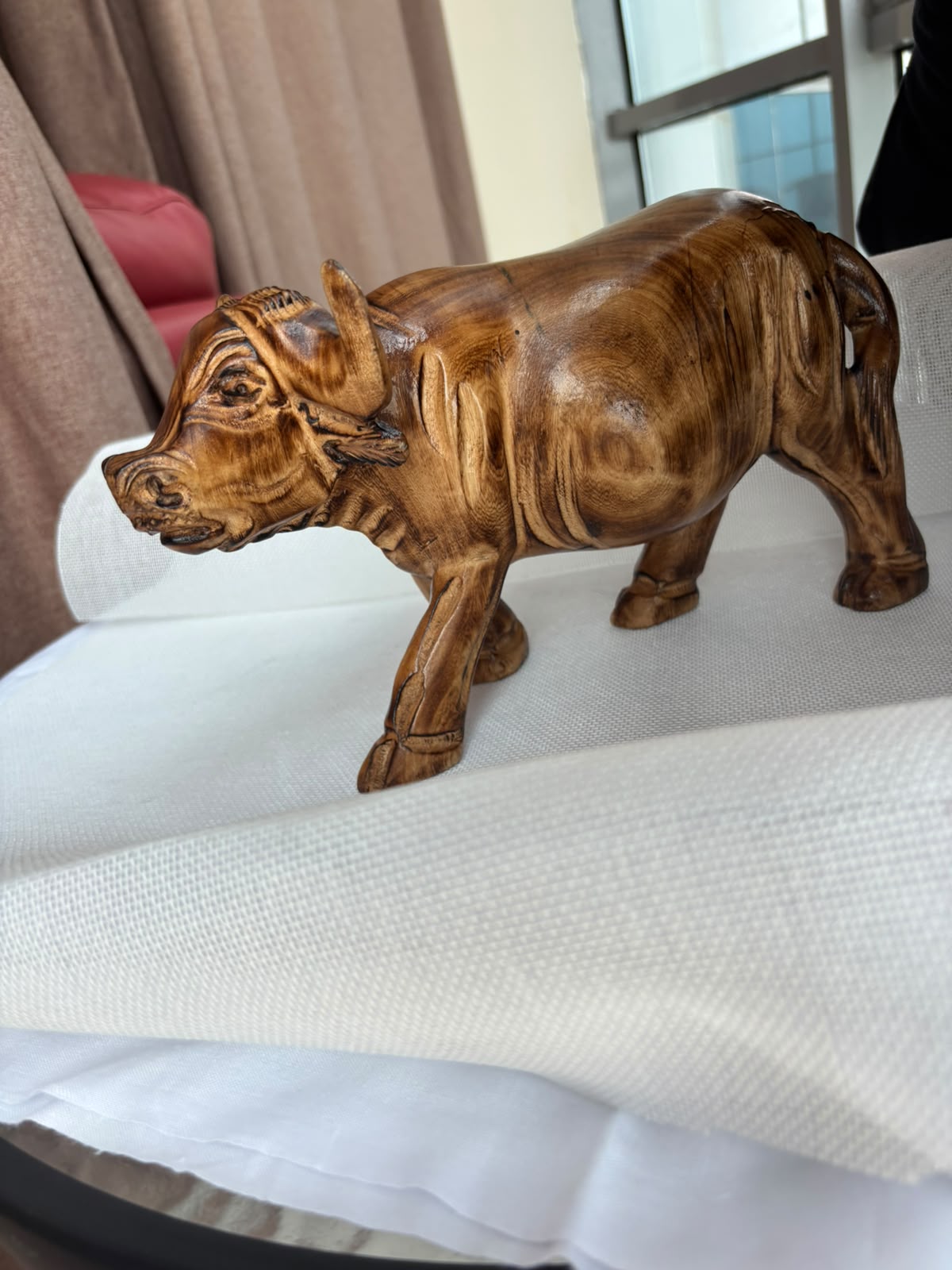 Hand-carved wooden buffalo sculpture angled view