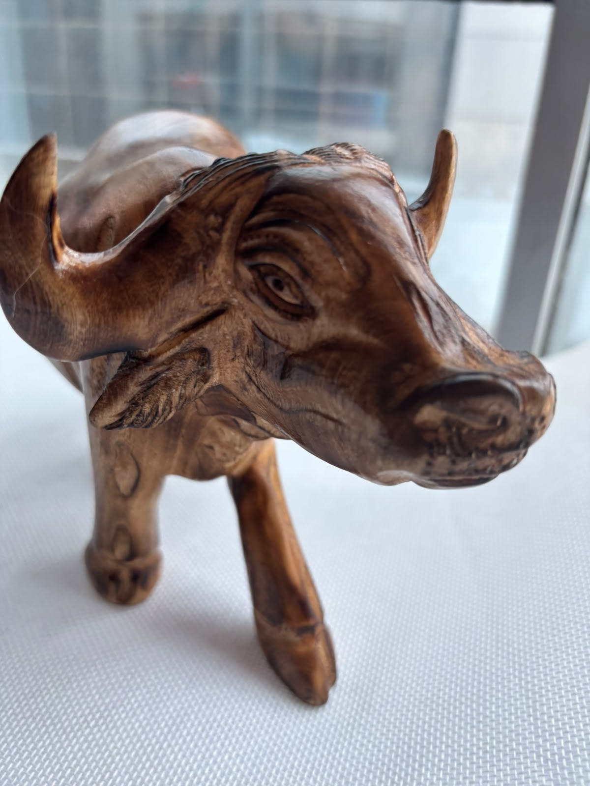 Hand-carved wooden buffalo sculpture face detail