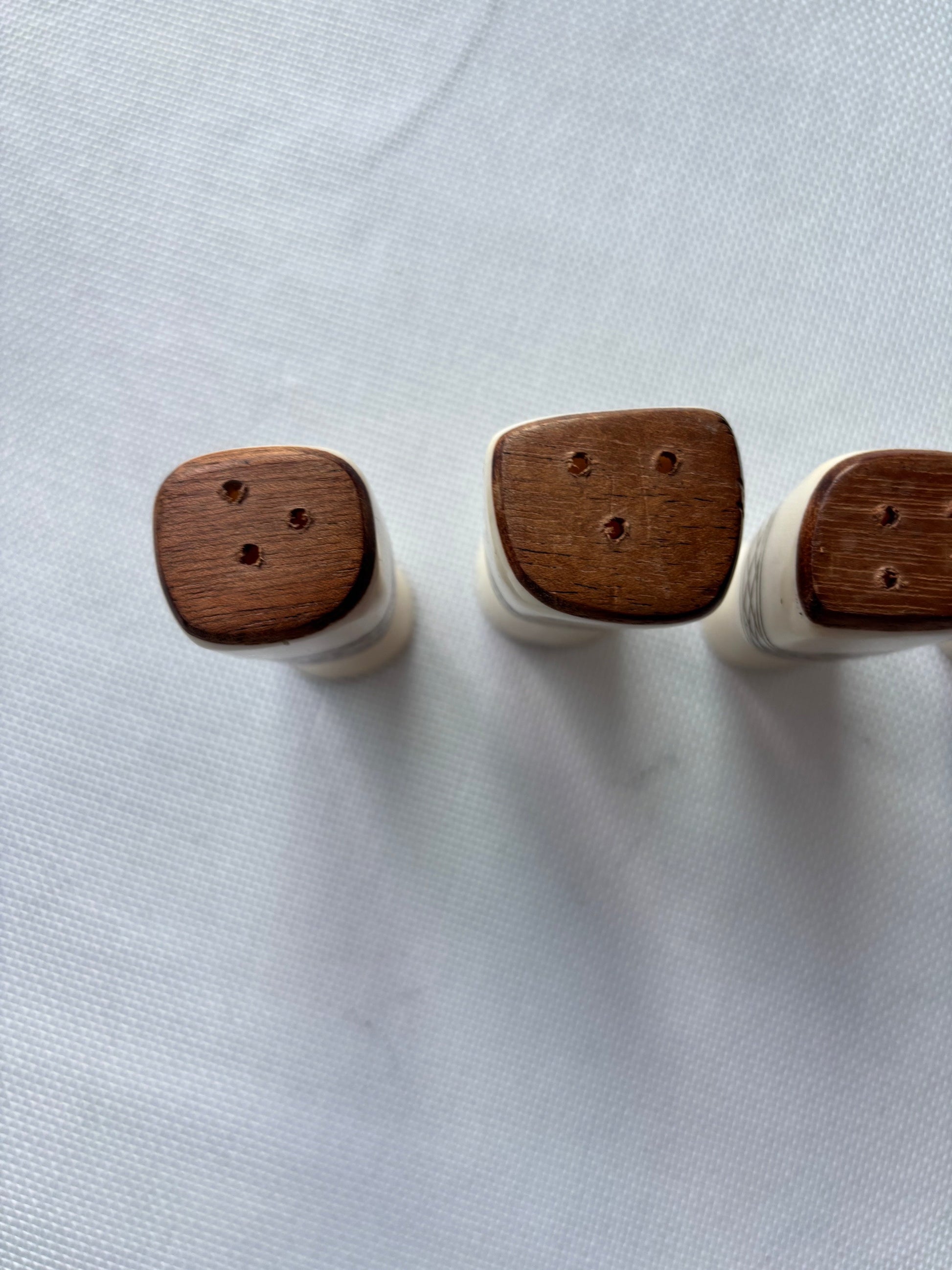 Carved ivory-tone salt and pepper set wooden top detail