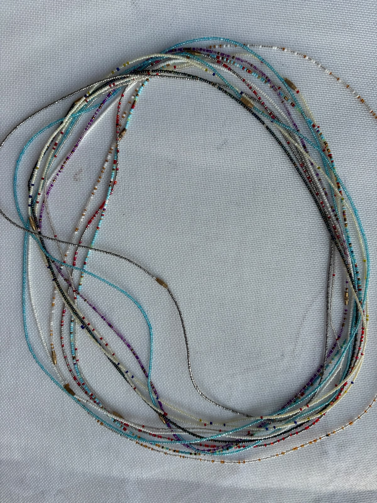 Long assorted waist bead strands in turquoise ivory silver and multicolour