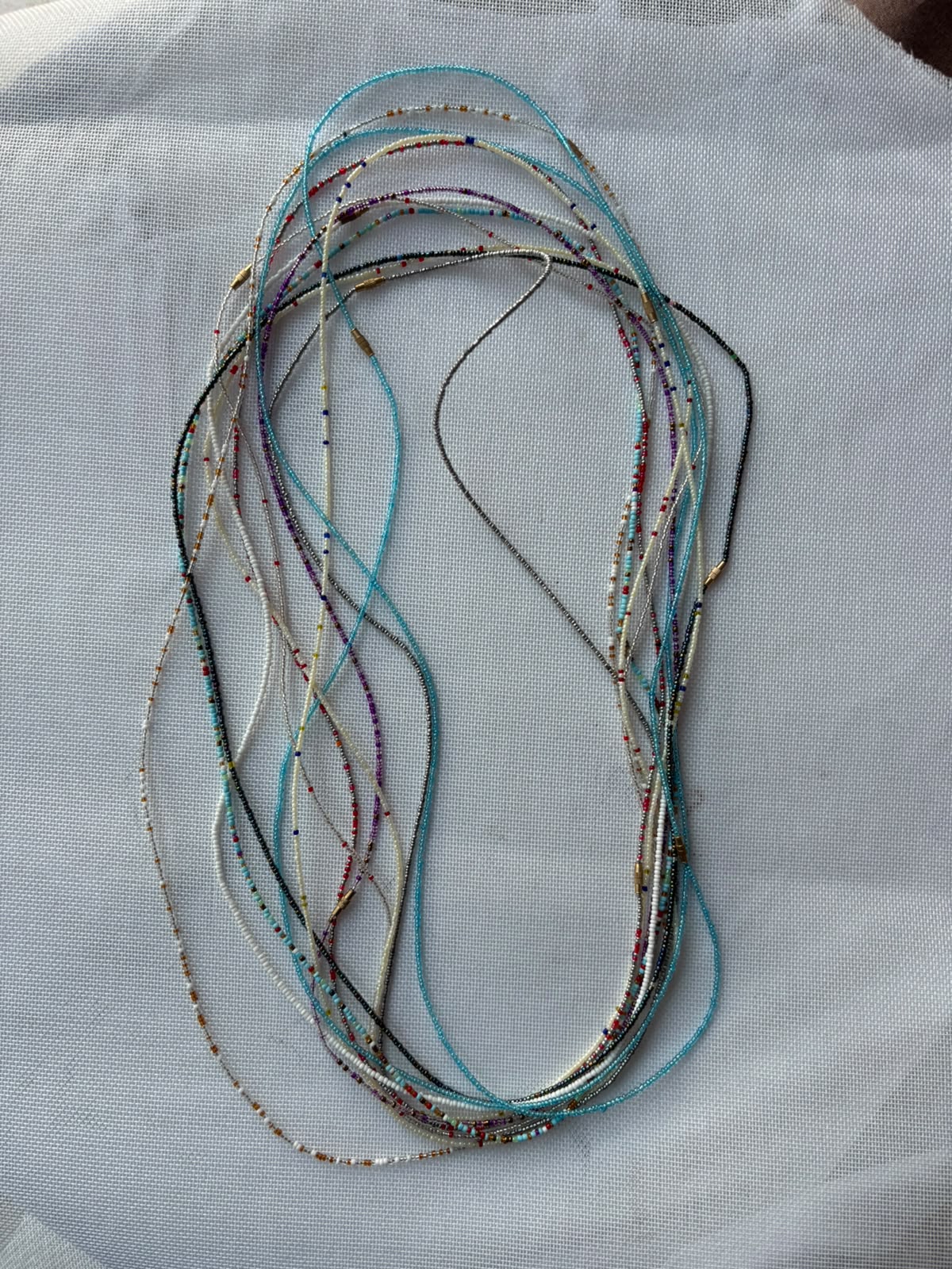 Assorted handcrafted waist beads displayed in full lengths